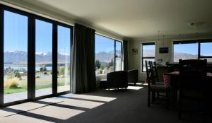 a room with a table and chairs and large windows at Walter Black Place - Lake Tekapo in Lake Tekapo