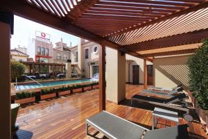 an outdoor patio with a swimming pool and a wooden deck at Casa Consistorial in Fuengirola