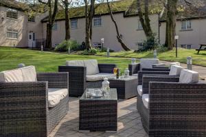 - une terrasse avec des tables et des chaises en osier dans l'établissement Best Western Bolholt Country Park Hotel, à Bury