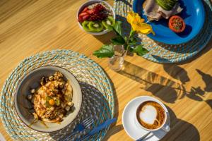 a table with two plates of food and a cup of coffee at Camelina Suites in San Antonio Bay