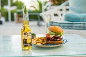 a sandwich and french fries on a plate with a bottle of beer at Camelina Suites in San Antonio Bay