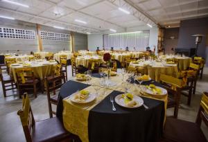 a large room with tables and chairs with plates of food at Pousada São Chico Eco Village in São Francisco de Paula