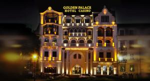 Un edificio iluminado con un cartel. en Golden Palace Batumi Hotel & Casino, en Batumi