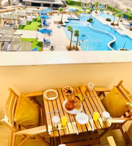 einen Tisch mit Speisen und Poolblick in der Unterkunft Luxury Hurghada Self-Catering Apartments & Studios, Al Dau Heights in Hurghada