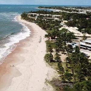 an aerial view of a beach with palm trees at Village AREIAS ITACIMIRIM - PÉ NA AREIA in Itacimirim
