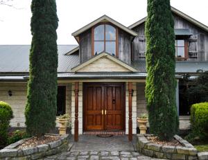 a house with a wooden door and two trees at The George at Yering in Yering +14 photos
