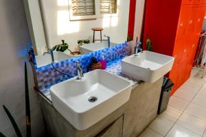 une salle de bains avec deux lavabos sur un comptoir dans l'établissement Buton Backpacker Lodge, à Bandung