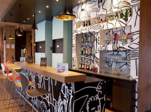 a bar in a restaurant with a black and white wall at Ibis Agen Centre Gare in Agen