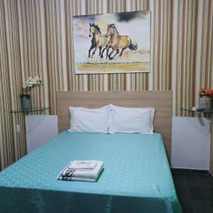 um quarto com uma cama azul com dois cavalos na parede em suite 02 - privativa, aconchegante e independente em Cuiabá