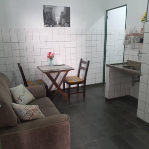 um quarto com uma mesa e um sofá e uma mesa e cadeiras em suite 02 - privativa, aconchegante e independente em Cuiabá
