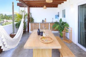 een woonkamer met een houten tafel en hangmatten bij El 55 Sayulita Stylish couple getaway rooftop pool in Sayulita