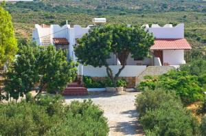 a large white house with trees in front of it at Elafonisi Resort by Kalomirakis Family in Elafonisi
