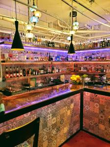 un bar con iluminación púrpura en un restaurante en The Clarendon Hotel and Spa, en Phoenix