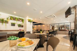 曼谷的住宿－The Home Hotel SHA，餐桌上放着一盘食物的餐厅