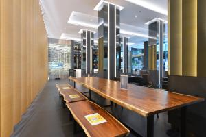 a row of wooden tables in a restaurant at Hotel Royal Bangkok@Chinatown in Bangkok