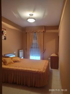 Un dormitorio con una cama grande y una ventana. en TU CASA EN MEQUINENZA CON WIFI, en Mequinenza