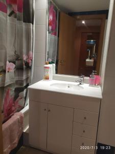 Un baño con un lavabo blanco y un espejo. en TU CASA EN MEQUINENZA CON WIFI, en Mequinenza