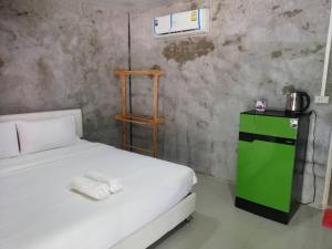 a bedroom with a white bed and a green cabinet at Banrimkhao pakchong in Pak Chong