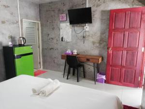 a room with a red door and a desk with a computer at Banrimkhao pakchong in Pak Chong