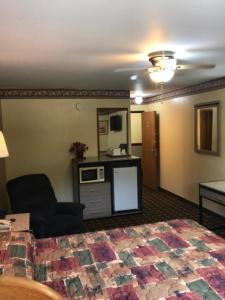 a hotel room with a bed and a kitchen at Deluxe Inn Nebraska City in Nebraska City