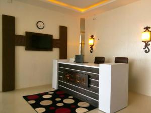 Habitación con escritorio y TV en la pared. en Hotel One DG Khan, en Taunsa