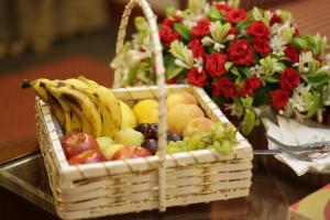 ein Obstkorb auf einem Tisch neben Blumen in der Unterkunft Hotel One DG Khan in Taunsa