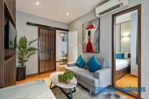 een woonkamer met een bank en een tafel bij The Art - Sunshine Apartment in Ho Chi Minh-stad
