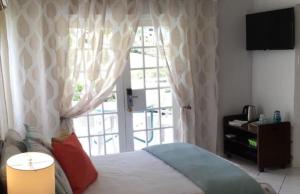 una camera con un letto e una grande finestra di Zander's Paradise @Mystic (Full) a Ocho Rios