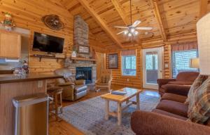a living room with a fireplace in a log cabin at Ozarks Oasis cabin in Branson