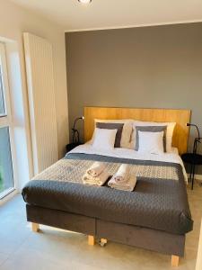 a bedroom with a bed with two towels on it at Apartament Nowy Verdon Ruda Śląska in Ruda Śląska