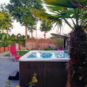 a hot tub in a backyard with a chair and a palm tree at La Grotta Hotel in Verona