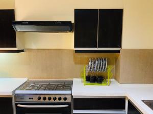 a kitchen with a stove top oven in a kitchen at Royal Service Apartments Gulberg in Lahore