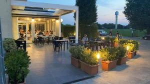 un patio con tavoli, sedie e posti a sedere di B&B Bertani a Modena
