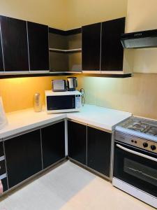 a kitchen with a microwave and a stove at Royal Two Bed Room Luxury Apartment Gulberg in Lahore