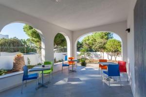 una stanza con tavoli, sedie e finestre di B&B "Perla del Sud" a San Vito lo Capo