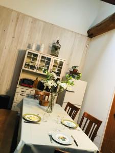 eine Küche mit einem Tisch mit Tellern und Blumen darauf in der Unterkunft L'AtelieR Guest House Yonago in Yonago