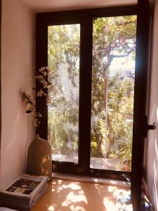 una ventana en una habitación con un libro y un jarrón en Galaria House, en Moutoullas