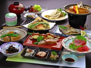 une table avec de nombreuses assiettes de nourriture dans l'établissement Echigoya Ryokan, à Ogano