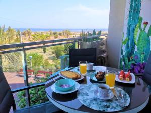 stół z jedzeniem i napojami na balkonie w obiekcie El remanso II w mieście La Manga del Mar Menor