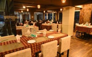 jadalnia ze stołami i krzesłami w restauracji w obiekcie Alhind Calicut Tower w mieście Kozhikode