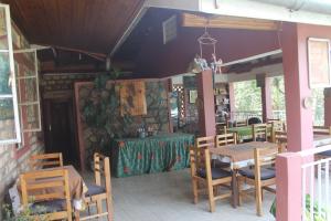 a restaurant with wooden tables and chairs and a table at Crater Bay Cottages in Kabale