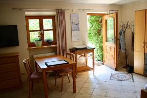 una sala da pranzo con tavolo e una porta che conduce a un patio di Ferienwohnung Fanese a Flintsbach am Inn