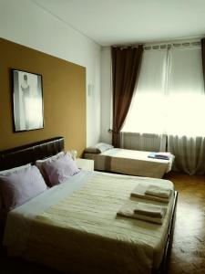 a hotel room with two beds and a window at B&B in Arena L' Opera in Verona