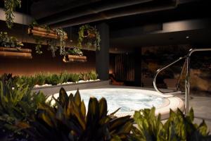 a hot tub in a courtyard with plants at Fletcher Strandhotel Haamstede in Burgh Haamstede
