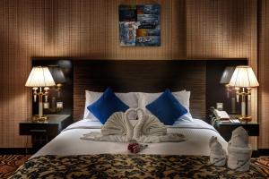 
سرير أو أسرّة في غرفة في Sharjah Palace Hotel
