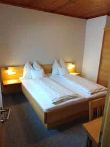 two beds in a hotel room with white pillows at Ferienhaus Regina in Werfenweng +26 photos
