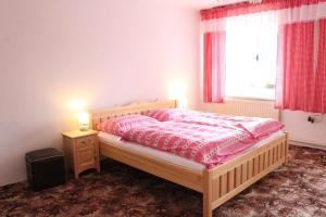 a bedroom with a bed with pink sheets and a window at Chalupa u Smolíků in Brtnice