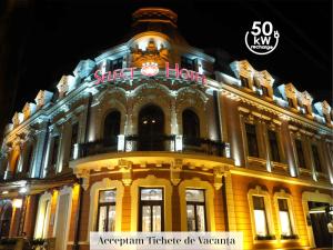 a building with a sign on top of it at night at Hotel Select in Iaşi