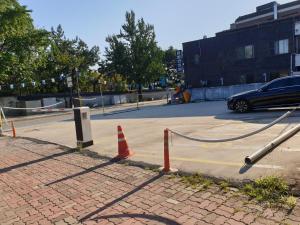 eine Straße mit orangefarbenen Kegeln und einem Auto auf einem Parkplatz in der Unterkunft Ddlanche Guesthouse New Building in Jeonju