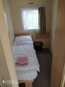 a small bed in a small room with a window at Chata Darwin in Terchová